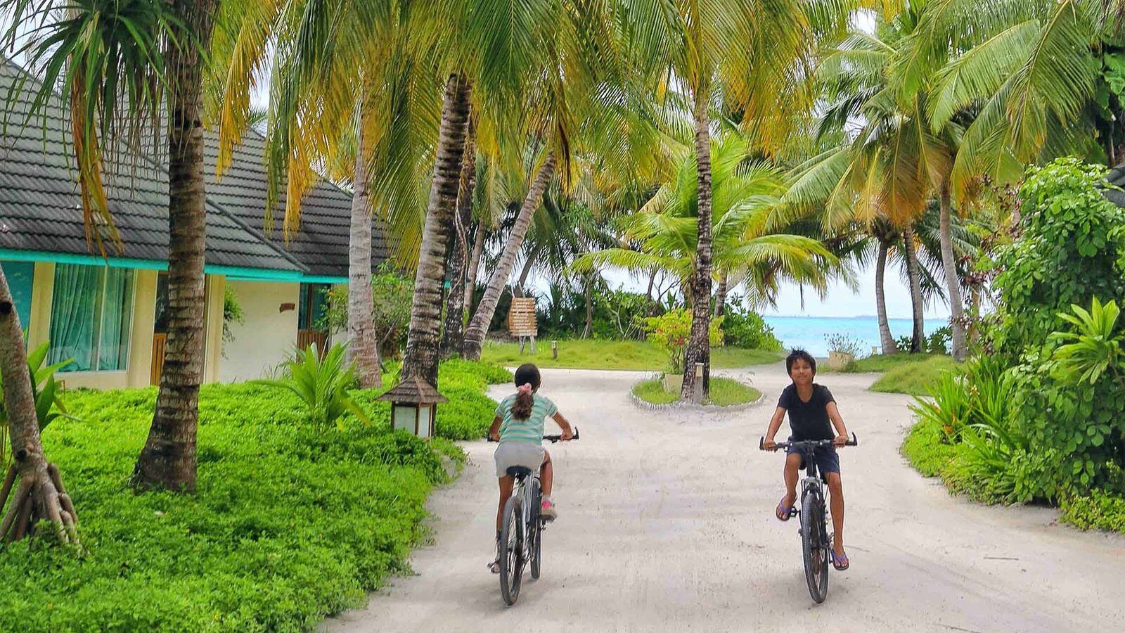 家庭旅客在 Canareef Resort Maldives 島上騎單車