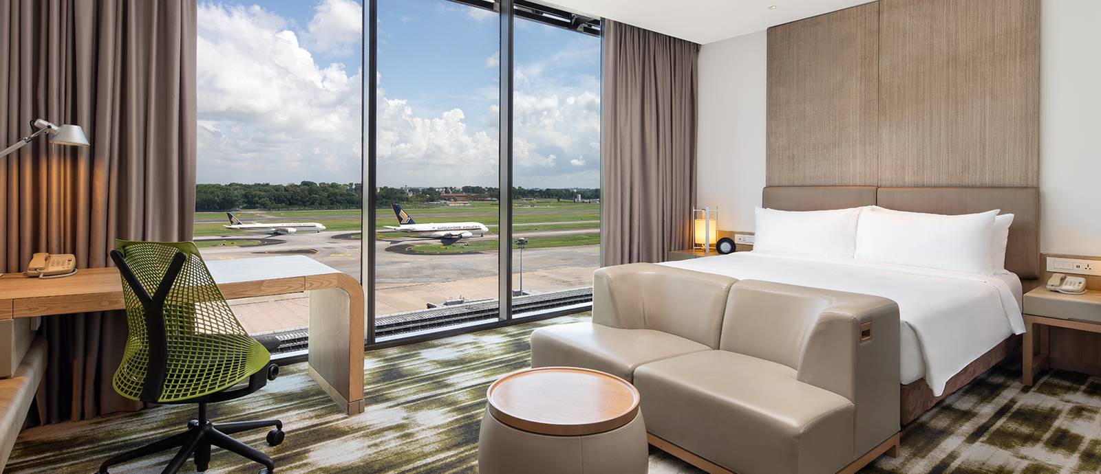 Crowne Plaza Changi Airport 客房大床與窗外停機坪上的飛機